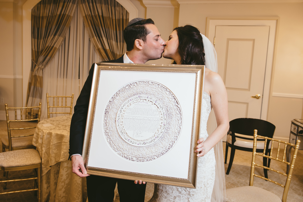 A couple excitedly unwrapping a customized Ketubah gift.